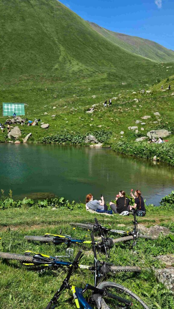 Riders approaching the dramatic Chaukhi Massif peaks on mountain bikes, Georgia