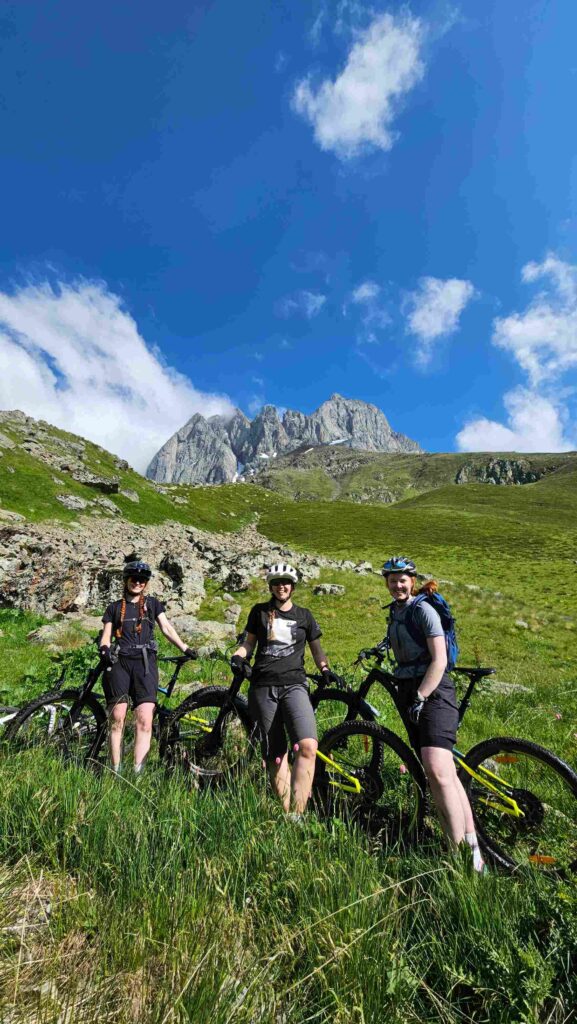 Mountain biker on a singletrack trail in Juta Valley with Caucasus mountains behind