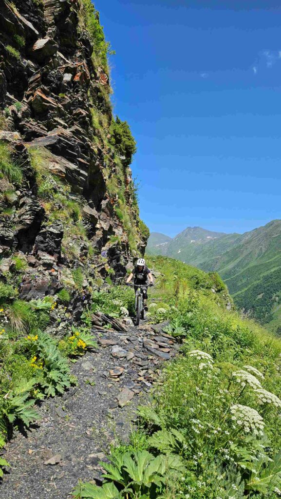 Rider on a technical rocky trail along a cliff face, Gudamakari Valley, Georgia